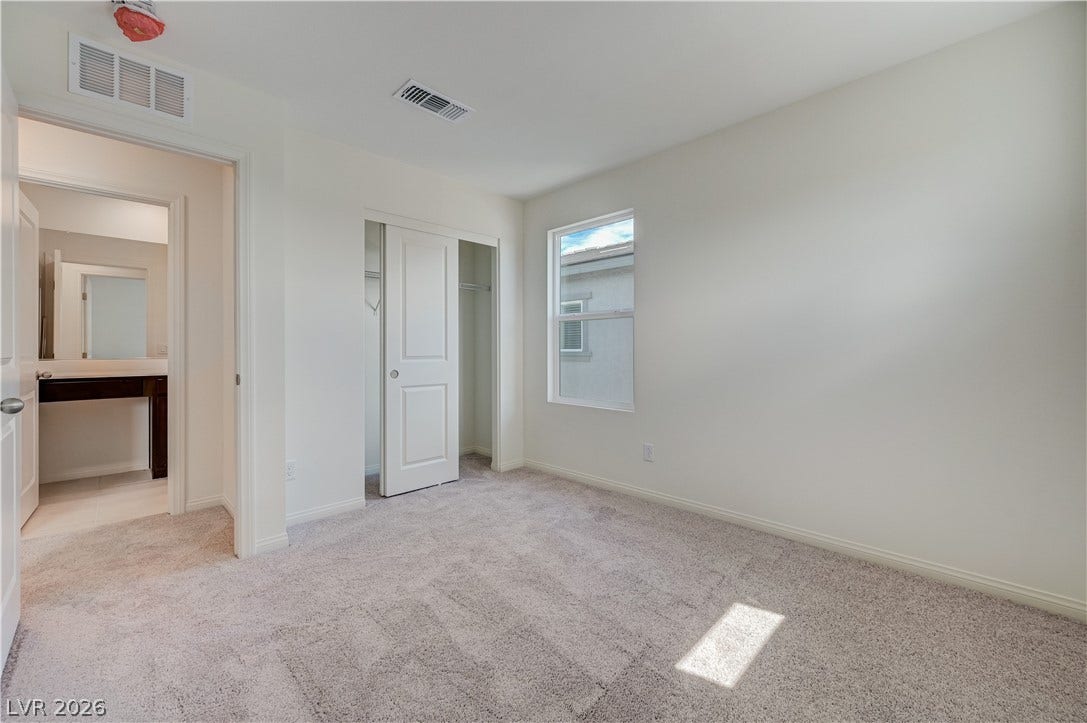 Plush carpeting and a neutral palette create a serene atmosphere in this secondary bedroom.
