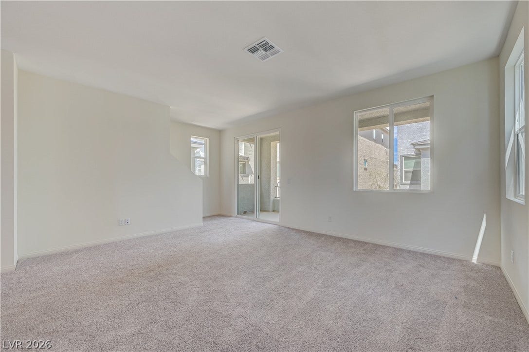 Plush wall-to-wall carpeting and sliding glass doors define this versatile second-story living space.