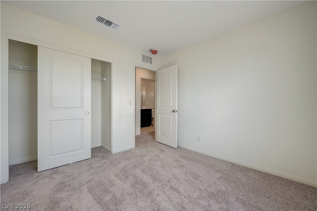 Soft carpeting underfoot and a sliding-door closet define this versatile secondary bedroom.