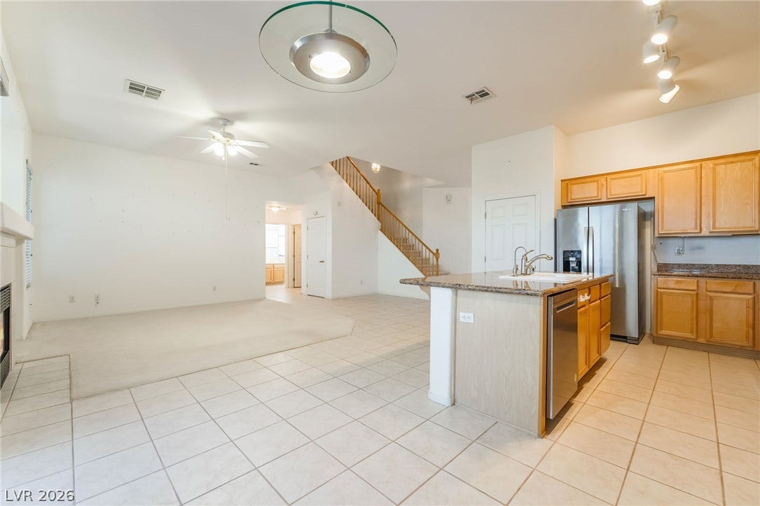 2722 Bass Lake Street, Henderson, NV 89052 An open floorplan seamlessly connects the tiled kitchen and carpeted living areas near the staircase.
