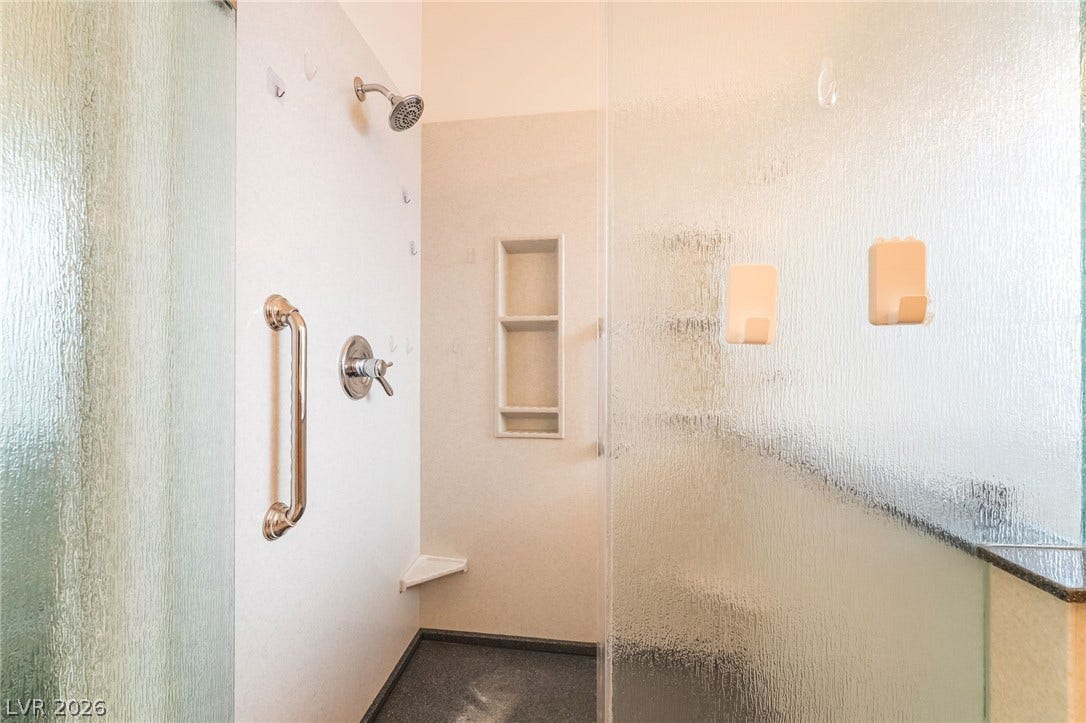2722 Bass Lake Street, Henderson, NV 89052 A walk-in shower features built-in shelving, safety handrails, and textured glass enclosures.