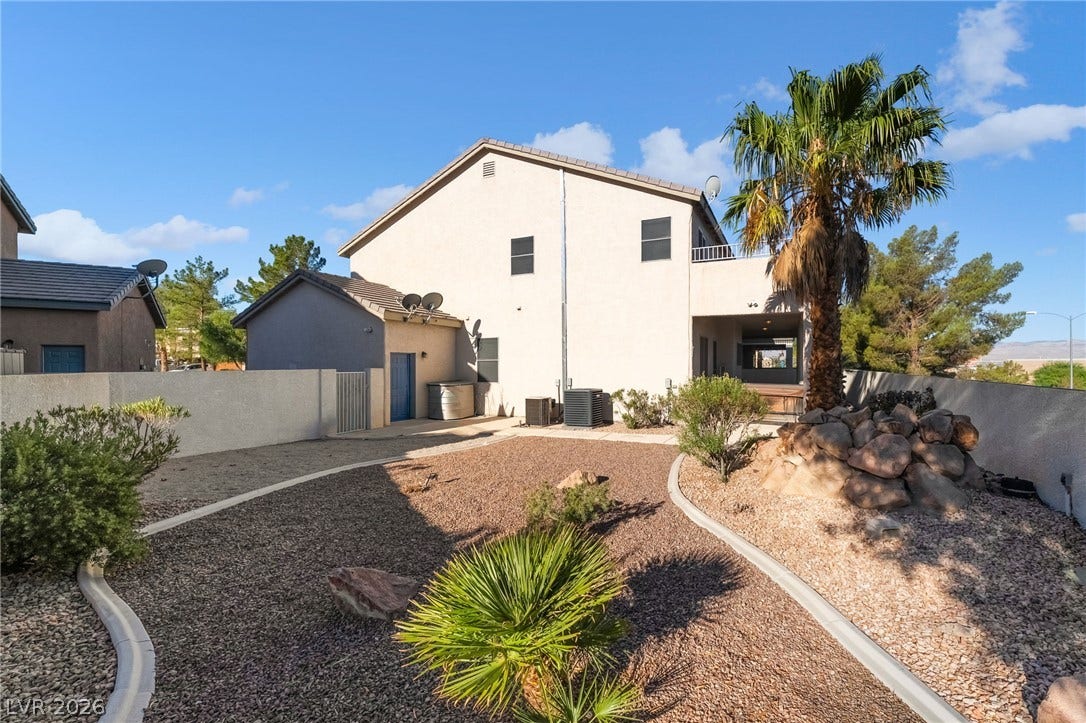 2722 Bass Lake Street, Henderson, NV 89052 Low-maintenance desert landscaping frames the rear of this multi-level home under clear blue skies.