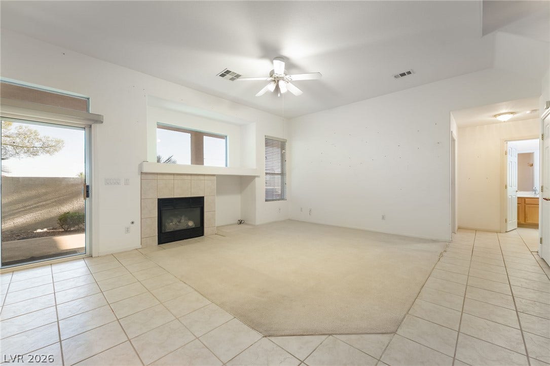 2722 Bass Lake Street, Henderson, NV 89052 An open living space features tile floors, carpet inlay, and a built-in fireplace.