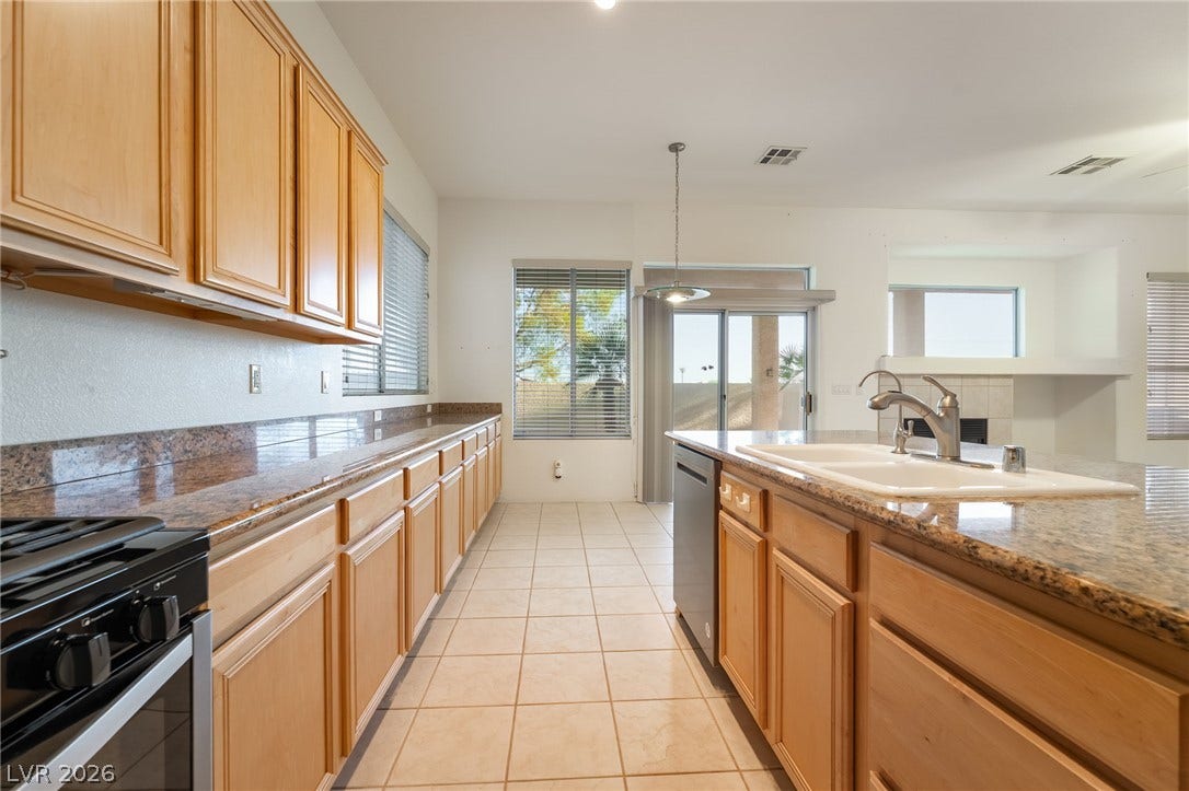 2722 Bass Lake Street, Henderson, NV 89052 Polished granite countertops complement warm wood cabinetry in this open kitchen layout.