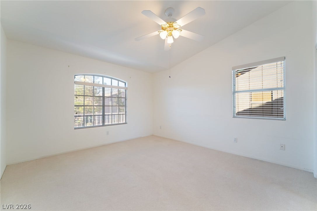 2722 Bass Lake Street, Henderson, NV 89052 Vaulted ceilings and broad windows enhance this carpeted bedroom.
