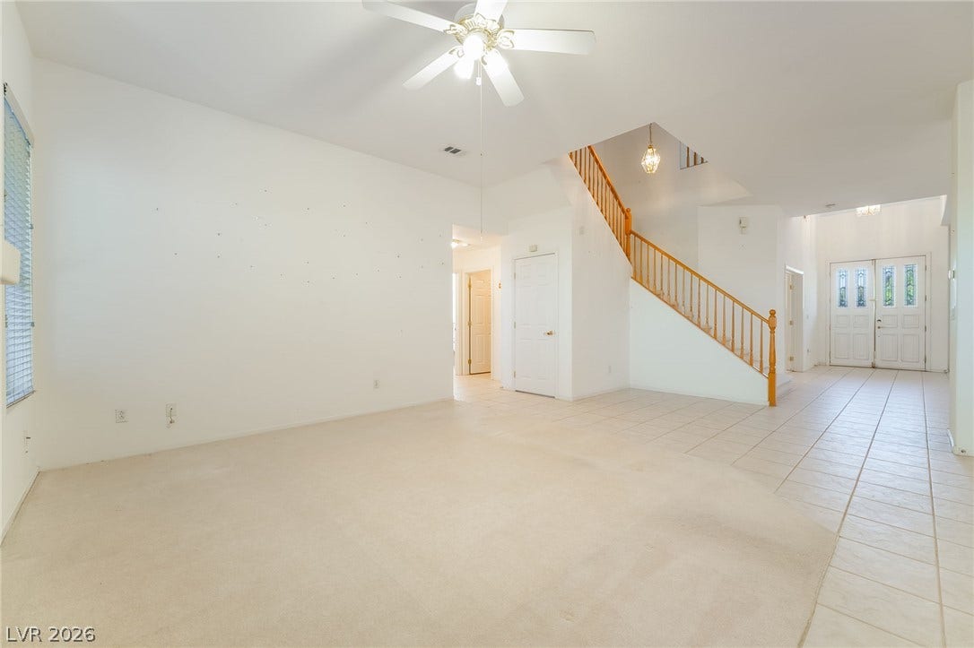 2722 Bass Lake Street, Henderson, NV 89052 High ceilings and a classic wooden staircase define this airy, open-concept entryway and living area.
