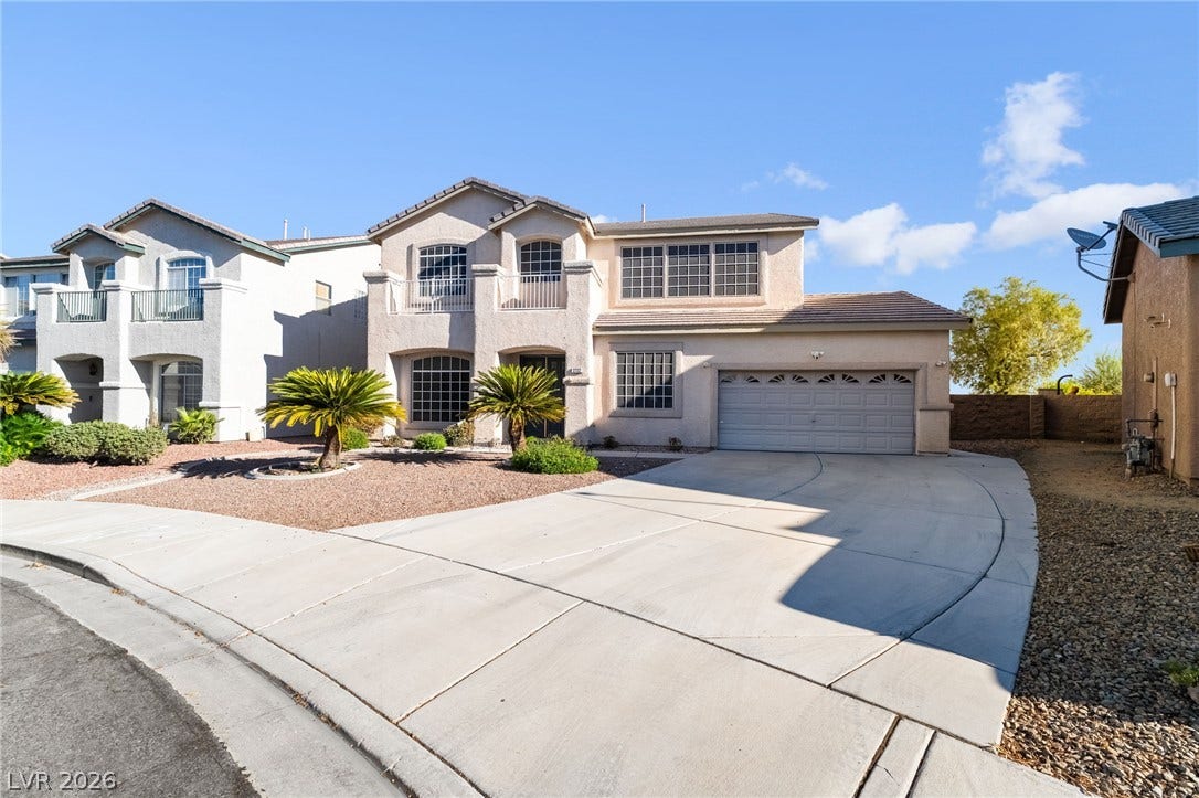2722 Bass Lake Street, Henderson, NV 89052 An attractive multi-level facade showcases stucco construction, a spacious concrete driveway, and desert landscaping.