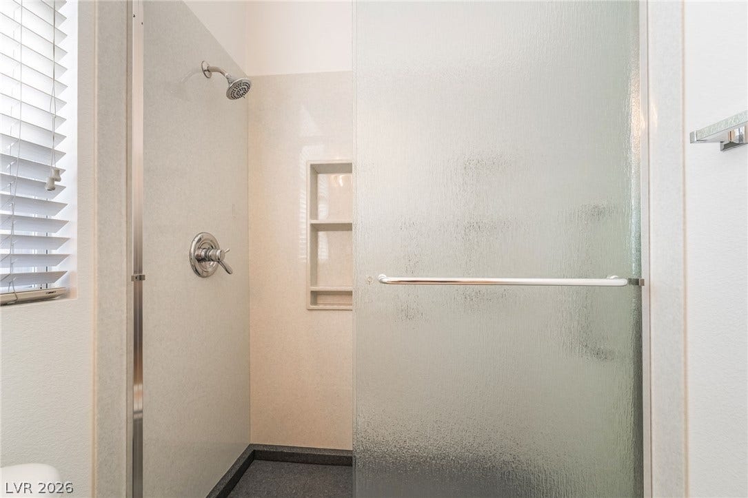 2722 Bass Lake Street, Henderson, NV 89052 Textured sliding glass doors enclose a walk-in shower featuring convenient built-in shelving.