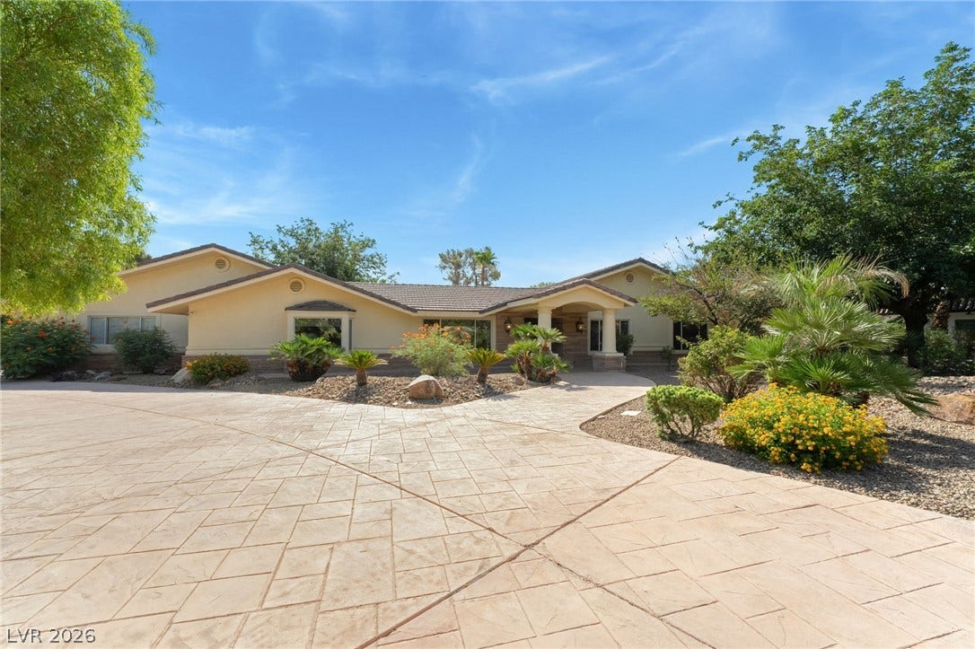 7154 Ranchito Circle, Las Vegas, NV 89120 An expansive stamped concrete driveway welcomes visitors to this elegant single-story home.