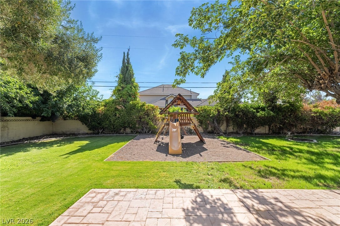 7154 Ranchito Circle, Las Vegas, NV 89120 Mature trees shade a spacious green lawn featuring a private play structure.