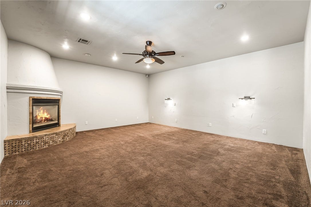 7154 Ranchito Circle, Las Vegas, NV 89120 A classic corner fireplace anchors this versatile living space featuring wall sconces and recessed lighting.