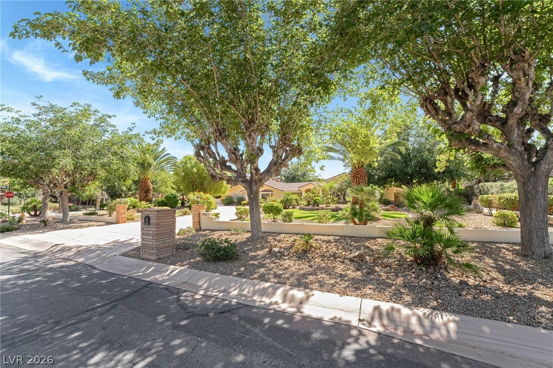7154 Ranchito Circle, Las Vegas, NV 89120 Mature trees shade the low-maintenance desert landscaping surrounding the paved driveway of this estate.