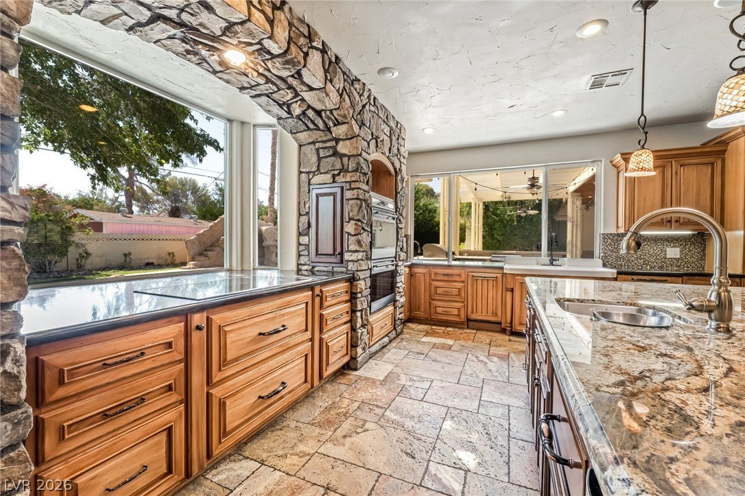 7154 Ranchito Circle, Las Vegas, NV 89120 Rich stone arches and polished granite countertops highlight this beautifully detailed culinary space.