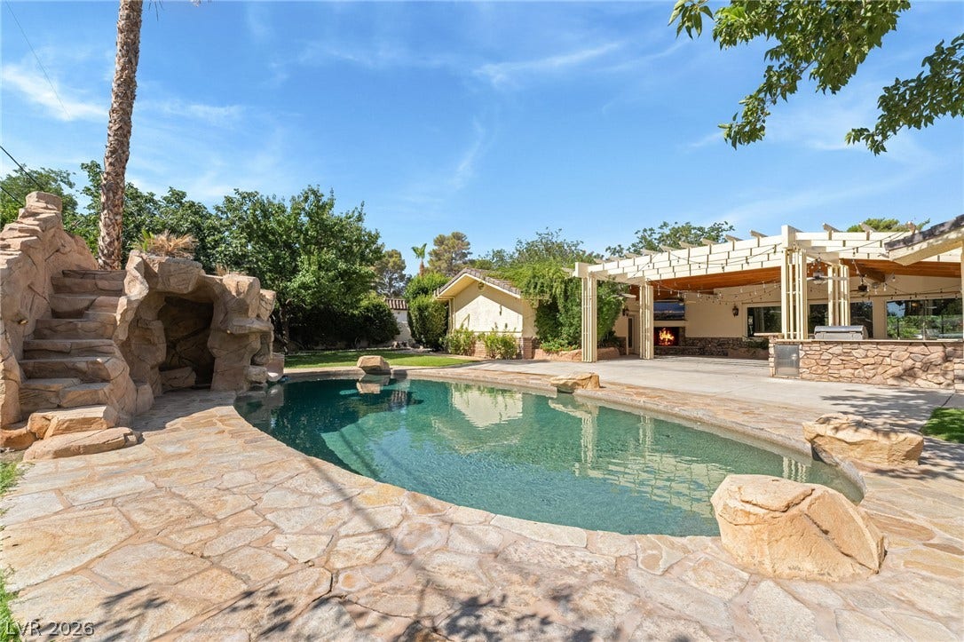 7154 Ranchito Circle, Las Vegas, NV 89120 An inviting backyard oasis features a flagstone-lined pool alongside a spacious covered patio area.