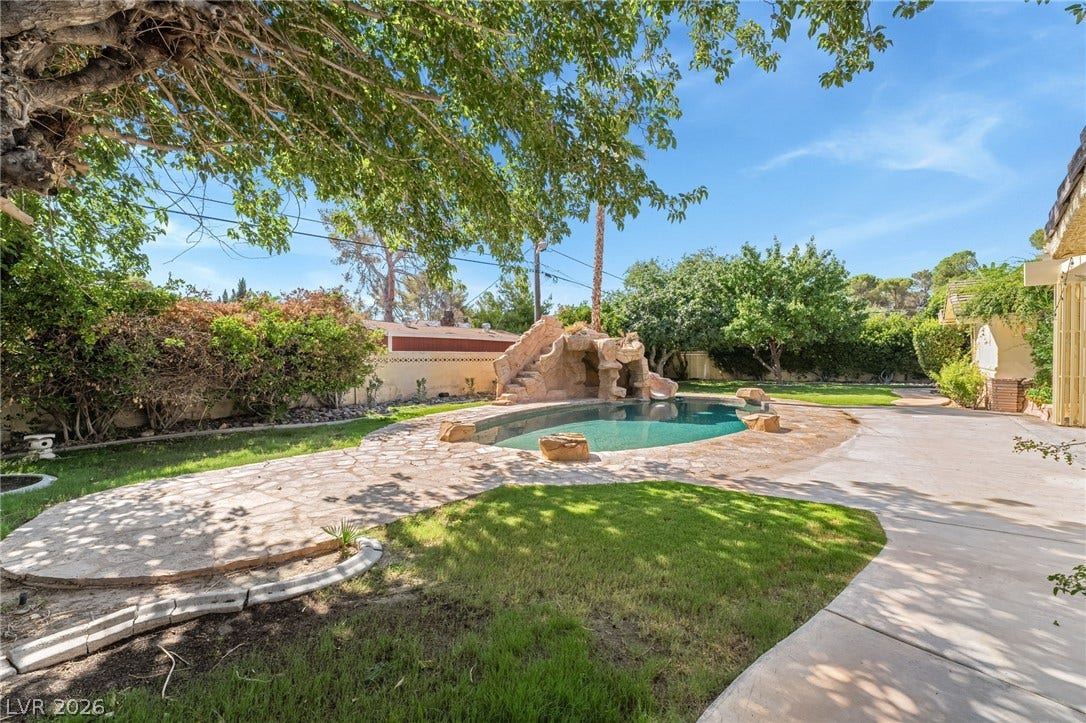 7154 Ranchito Circle, Las Vegas, NV 89120 A stone-paved patio surrounds an in-ground swimming pool complete with a custom rock slide.