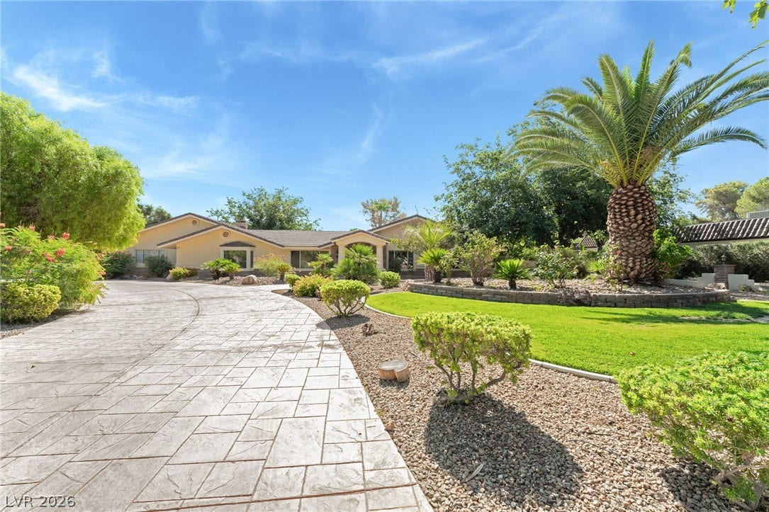 7154 Ranchito Circle, Las Vegas, NV 89120 Manicured tropical landscaping and a stamped concrete driveway lead to the sprawling single-level home.