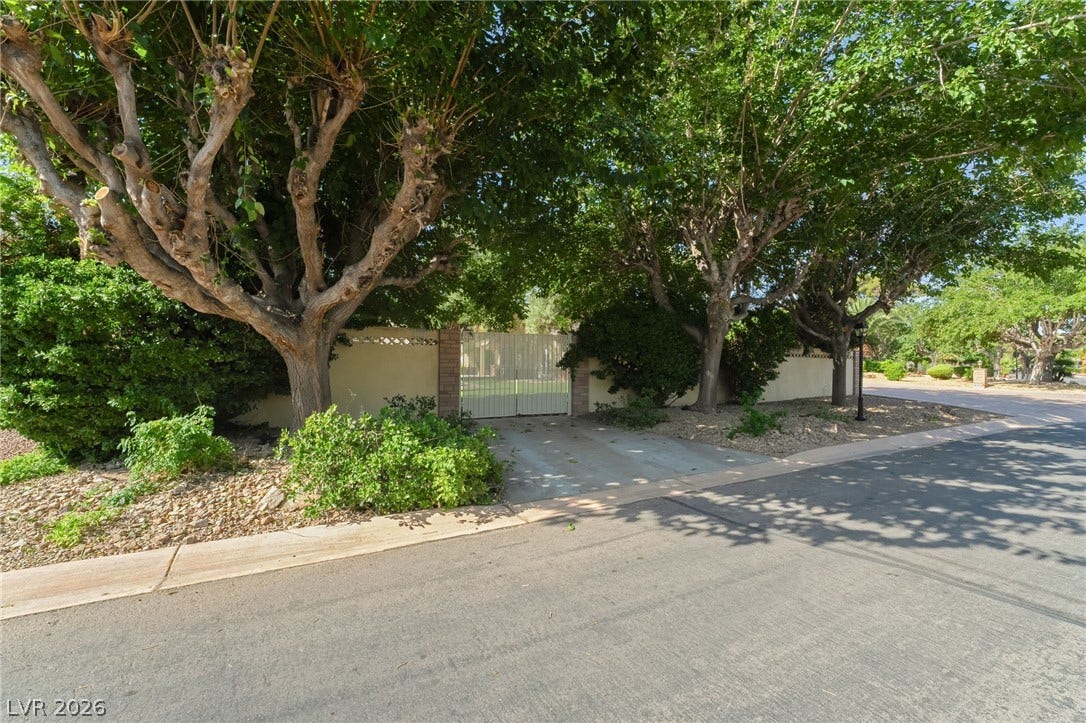 7154 Ranchito Circle, Las Vegas, NV 89120 Mature trees shade a private gated driveway leading to the property.