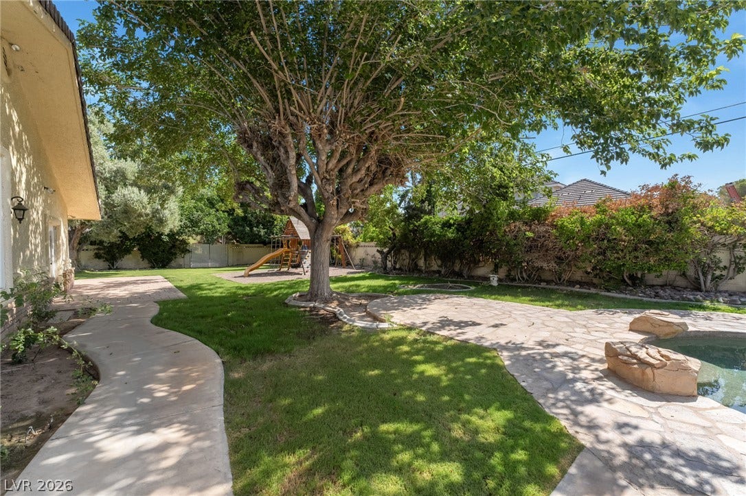 7154 Ranchito Circle, Las Vegas, NV 89120 Mature trees shade a spacious lawn featuring flagstone patios and a winding concrete pathway.