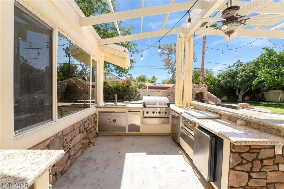 7154 Ranchito Circle, Las Vegas, NV 89120 An expansive covered outdoor kitchen features stone accents and premium stainless steel appliances.