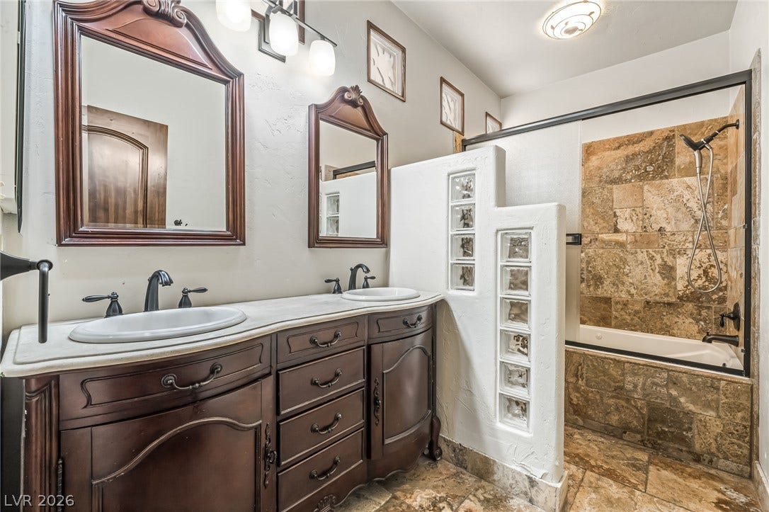 7154 Ranchito Circle, Las Vegas, NV 89120 Rich wood cabinetry paired with stone tile creates a warm, classic bath design.