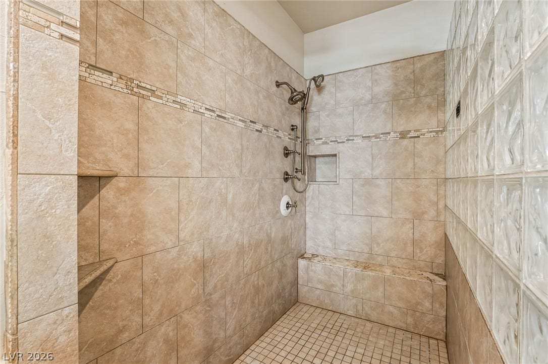 7154 Ranchito Circle, Las Vegas, NV 89120 Floor-to-ceiling tile work and a glass block wall define this custom walk-in shower.