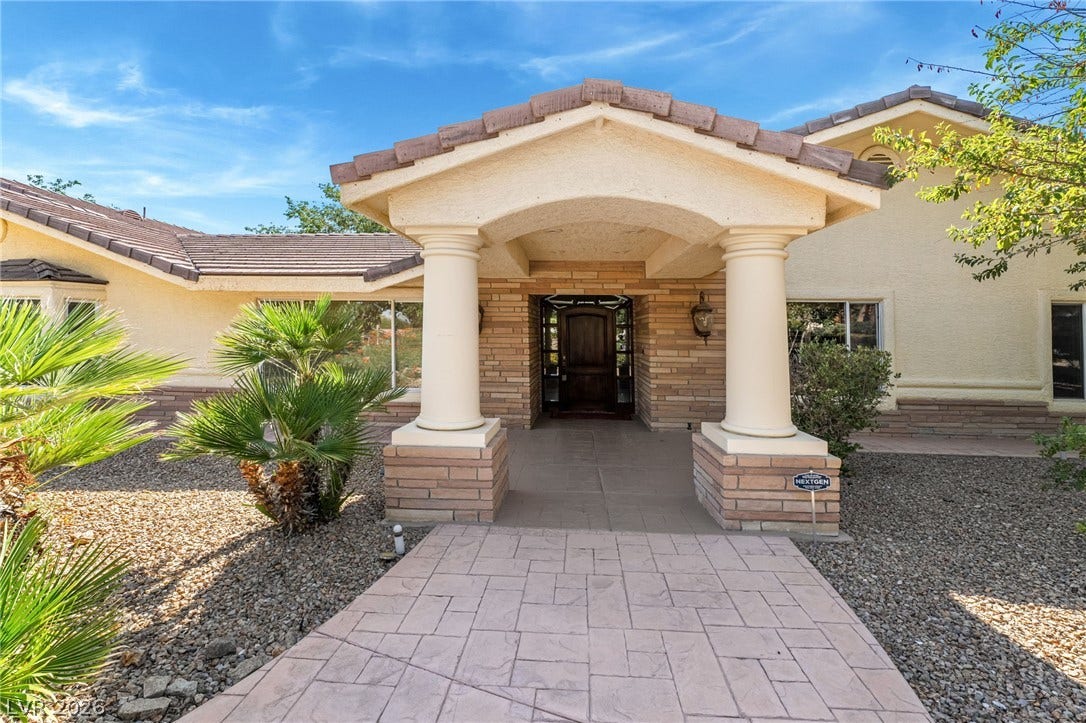 7154 Ranchito Circle, Las Vegas, NV 89120 Stately pillars frame the covered entrance of this elegant stone and stucco residence.