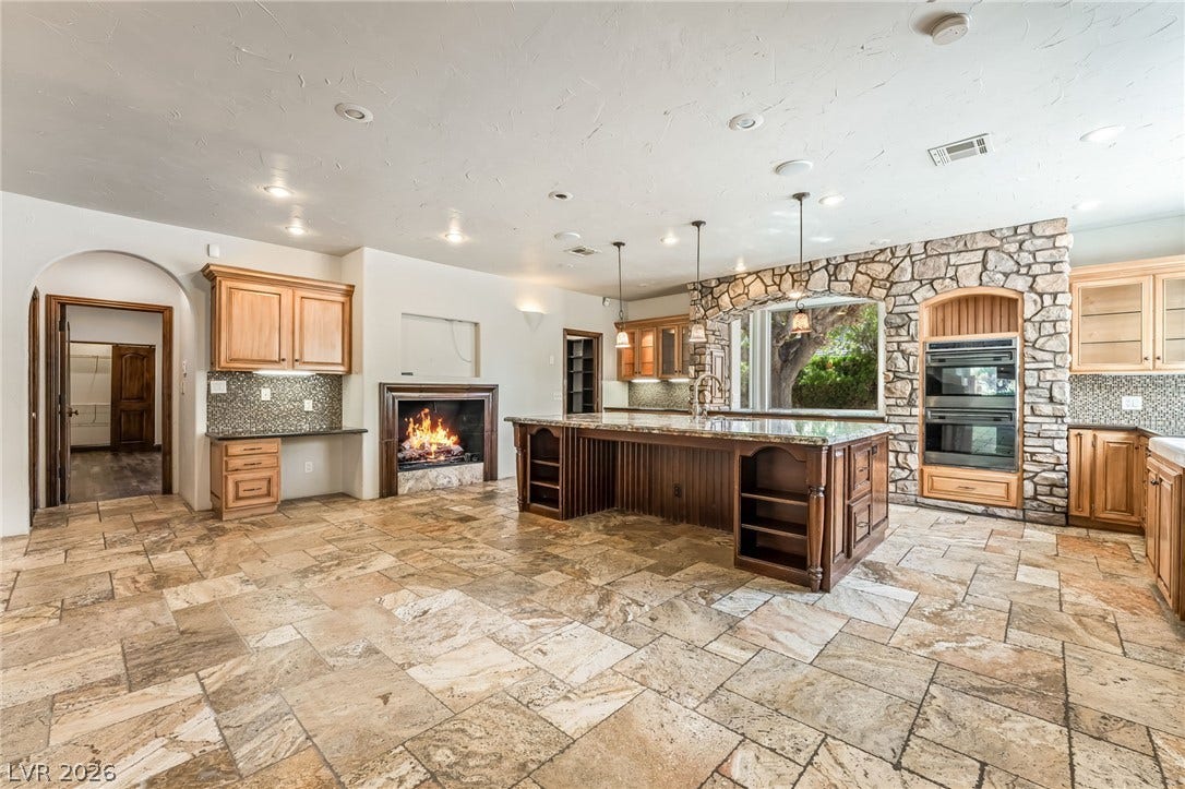 7154 Ranchito Circle, Las Vegas, NV 89120 A spacious kitchen features tile flooring, custom stone accents, and a cozy fireplace.