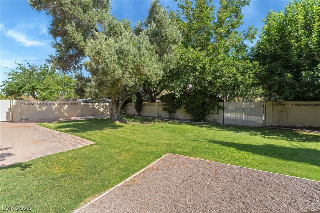7154 Ranchito Circle, Las Vegas, NV 89120 Mature trees frame a spacious, fully walled backyard complete with manicured lawn areas.
