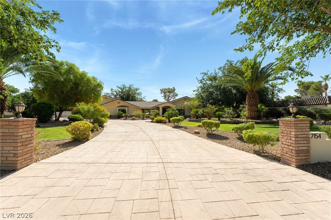 7154 Ranchito Circle, Las Vegas, NV 89120 A spacious stone driveway leads to this classic single-story home framed by mature trees.