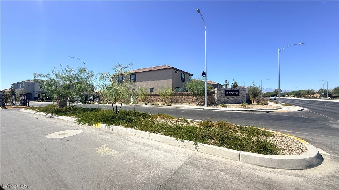 4240 Mount Bonnell Avenue, North Las Vegas, NV 89081 An inviting gated neighborhood entry features structured stone walls and desert landscaping under wide open skies.