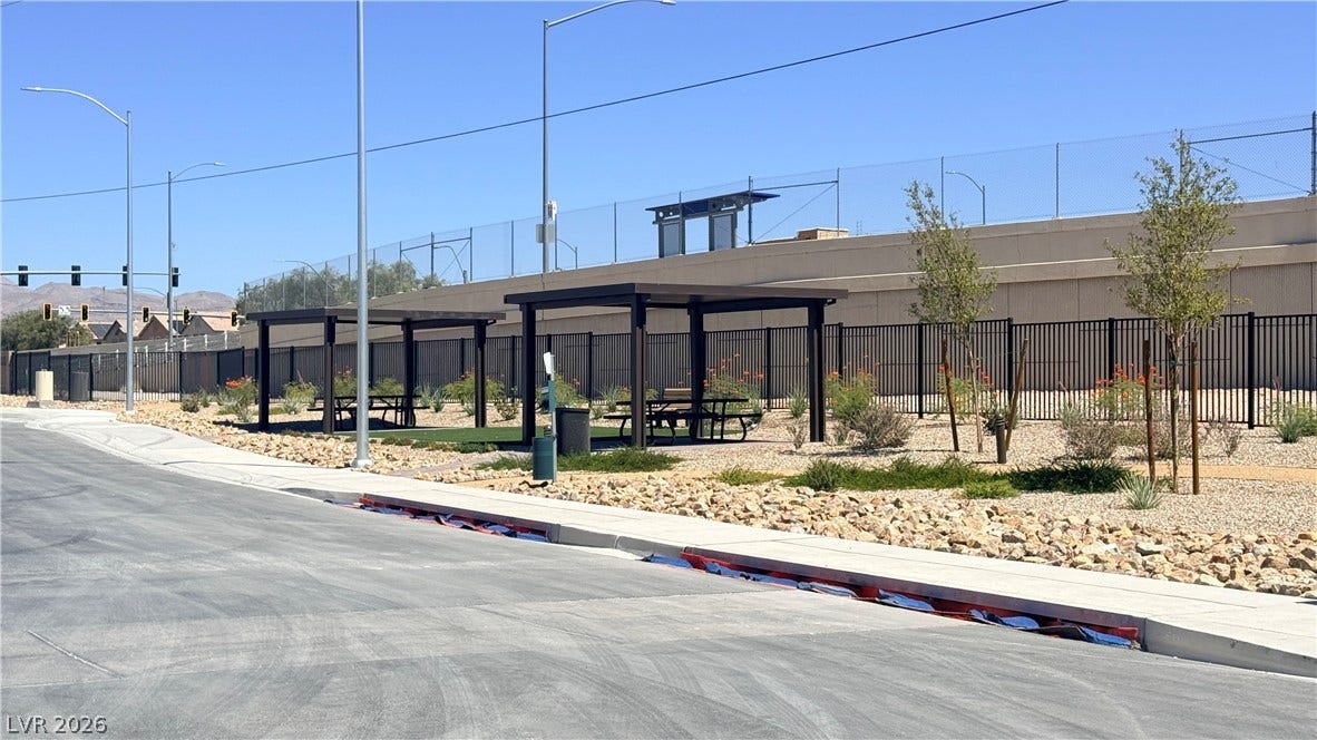 4240 Mount Bonnell Avenue, North Las Vegas, NV 89081 Fenced community park features covered picnic areas alongside paved sidewalks.