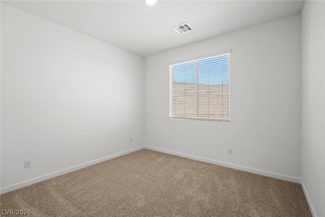 1670 Capri Falls Court, Henderson, NV 89011 A window brings natural light into this bedroom featuring soft carpeting.