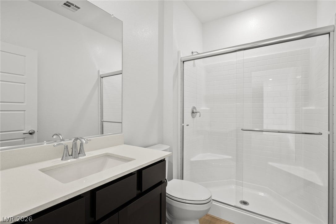 1670 Capri Falls Court, Henderson, NV 89011 A modern vanity with stone counters complements a spacious glass-enclosed shower.