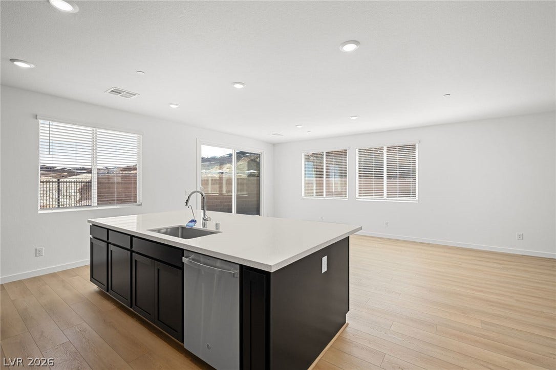 1670 Capri Falls Court, Henderson, NV 89011 An open floorplan seamlessly connects the modern kitchen space with a large, bright living area.
