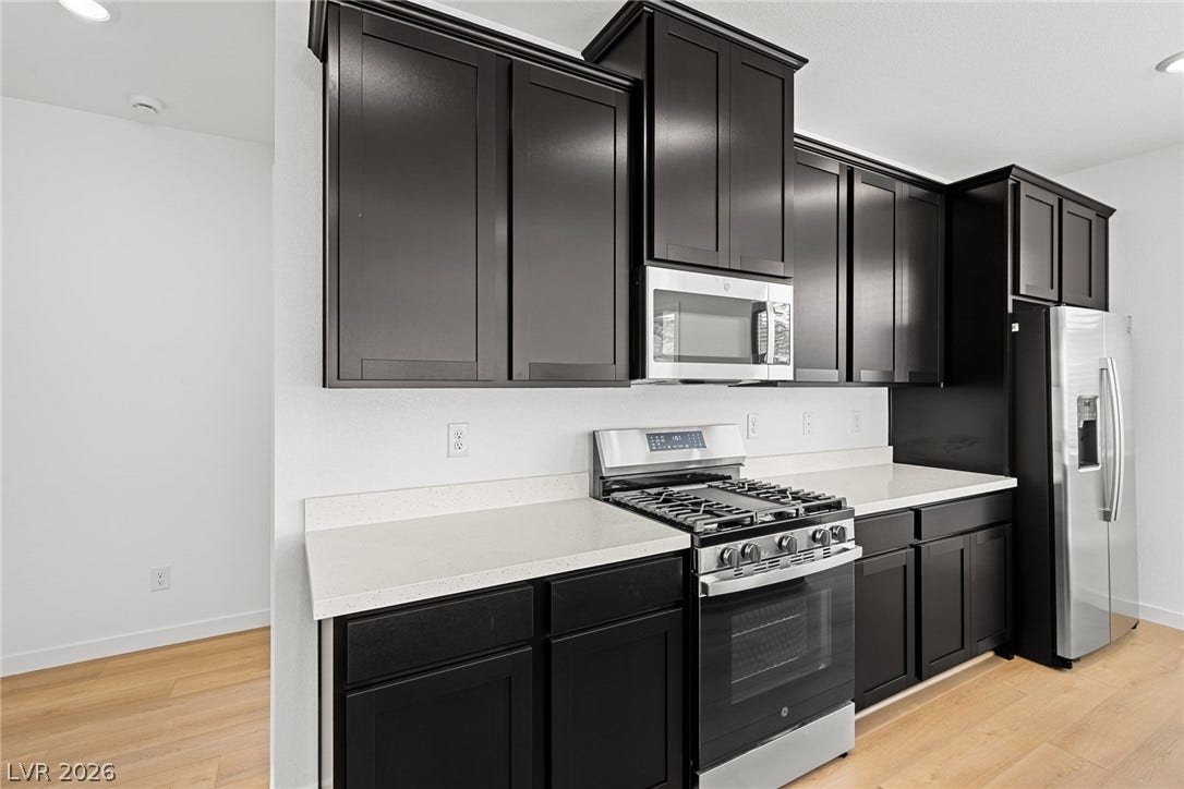 1670 Capri Falls Court, Henderson, NV 89011 Dark shaker cabinetry contrasts beautifully with clean stone countertops and natural wood floors.
