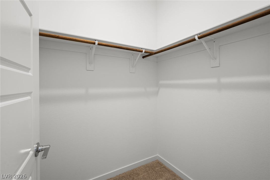 1670 Capri Falls Court, Henderson, NV 89011 A spacious walk-in closet includes carpet flooring and continuous hanging rods on two walls.