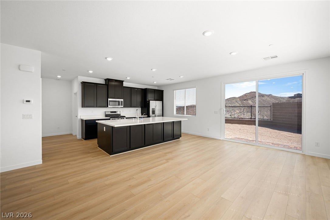 1670 Capri Falls Court, Henderson, NV 89011 Sliding glass doors open to outdoor views from this modern open-concept kitchen and living area.