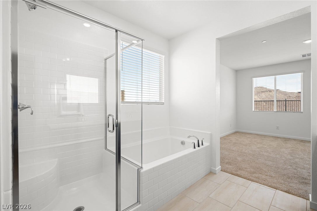 1670 Capri Falls Court, Henderson, NV 89011 Tiled floors and a soaking tub create a spa-like retreat adjacent to the carpeted bedroom.