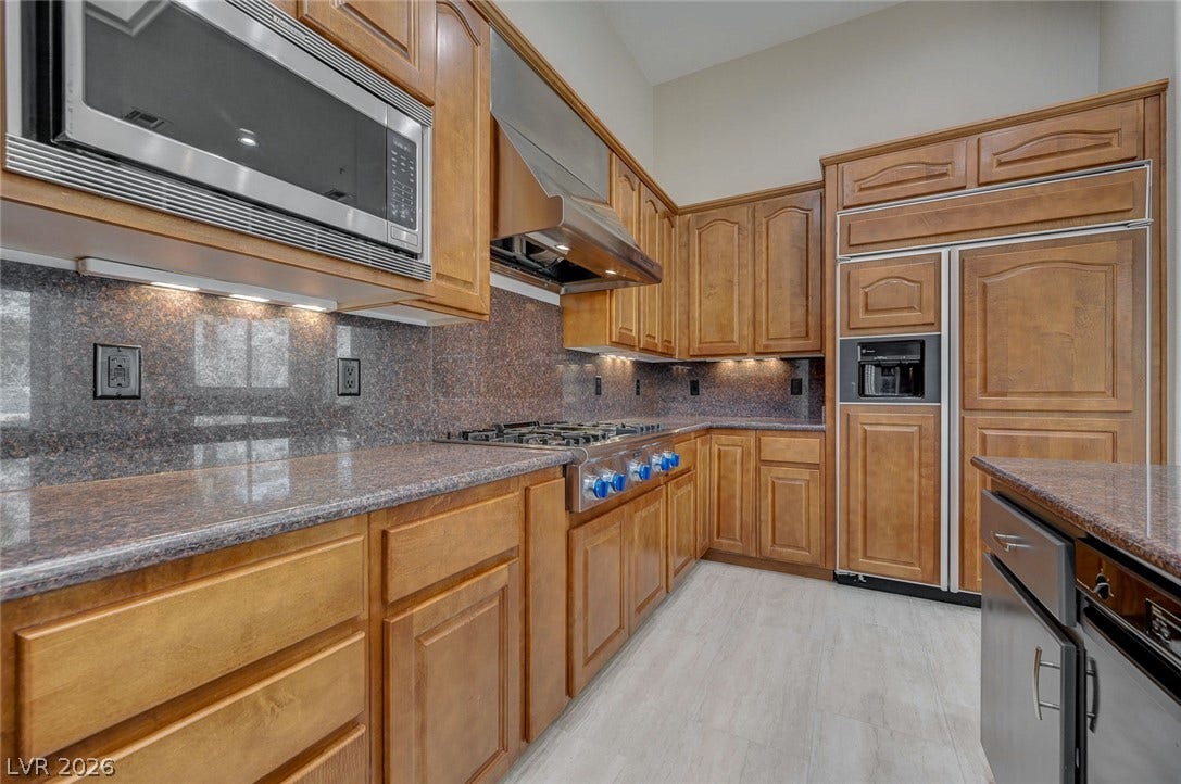 8 Starbrook Drive, Henderson, NV 89052 Gleaming stone countertops and custom wood cabinetry define this gourmet kitchen space.