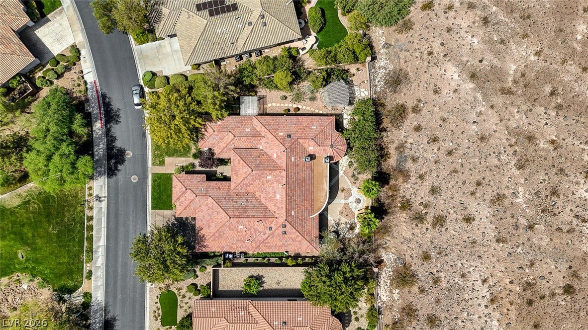 8 Starbrook Drive, Henderson, NV 89052 An aerial view showcases the property tile roof design bordering a natural desert landscape.