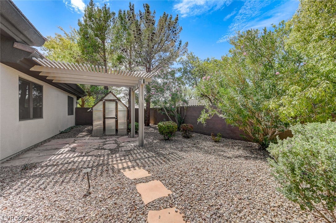 8 Starbrook Drive, Henderson, NV 89052 A spacious gravel yard features a custom pergola and a detached backyard storage shed.