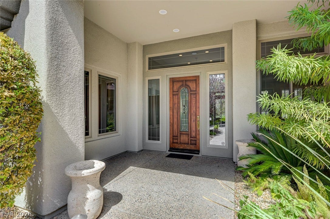 8 Starbrook Drive, Henderson, NV 89052 A handsome wood front door with decorative glass welcomes guests into this entry way.