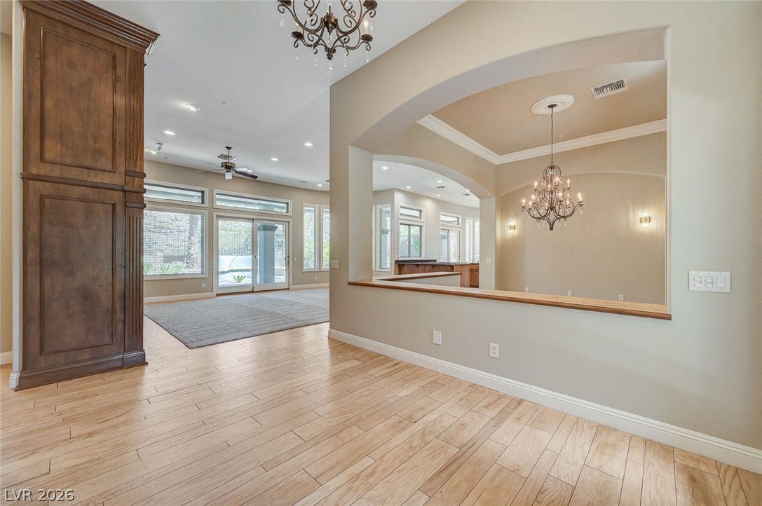 8 Starbrook Drive, Henderson, NV 89052 Polished wood-look flooring flows seamlessly beneath grand arched openings and classic crown molding.