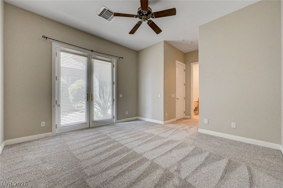 8 Starbrook Drive, Henderson, NV 89052 Glass doors open to the outdoors in this comfortable bedroom featuring soft neutral walls.