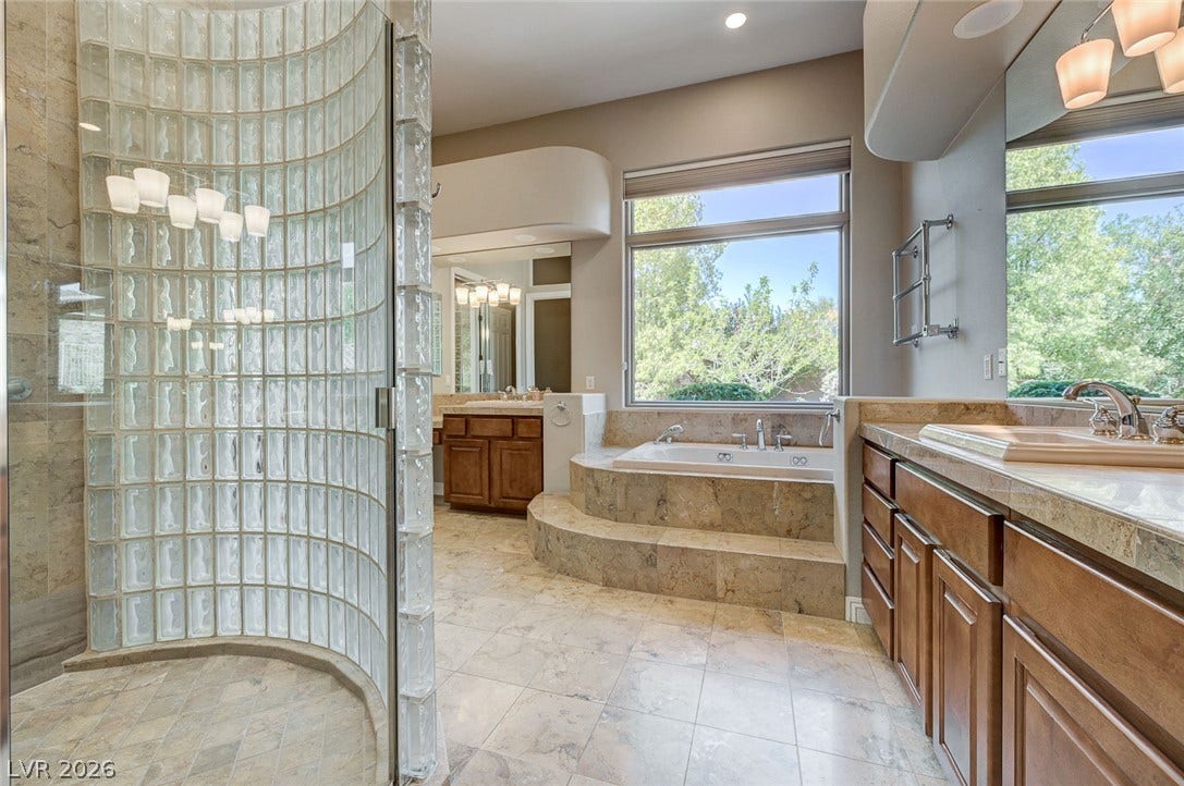 8 Starbrook Drive, Henderson, NV 89052 Stone tile floors and a glass-block walk-in shower elevate this spacious bathroom retreat.