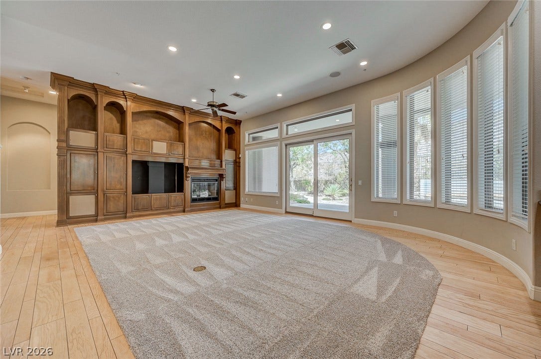 8 Starbrook Drive, Henderson, NV 89052 Rich wood built-ins and a curved window wall define this light-filled room with wood flooring.