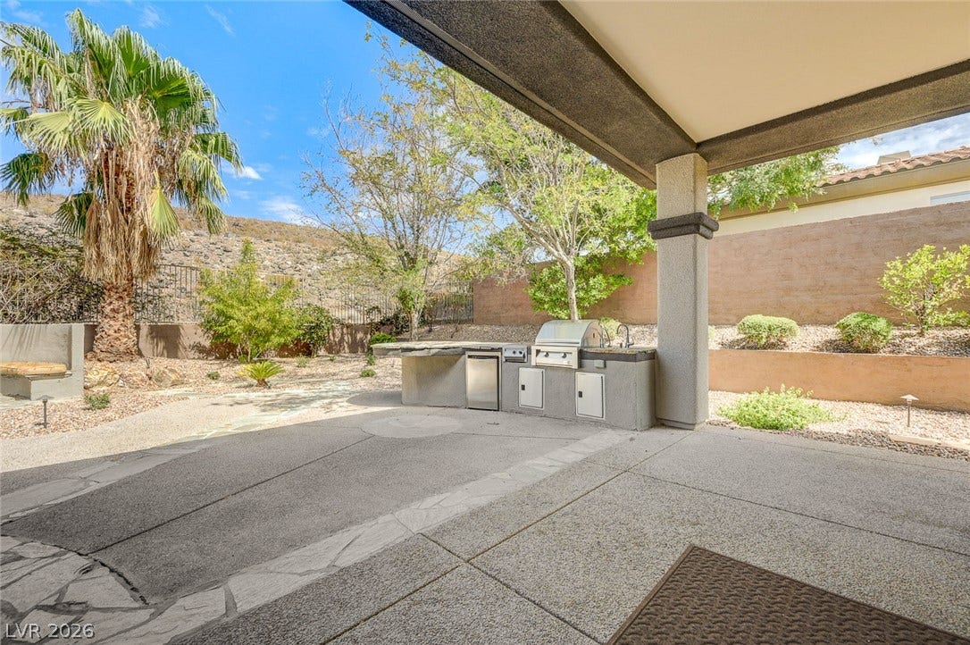 8 Starbrook Drive, Henderson, NV 89052 An inviting covered patio opens to a built-in outdoor kitchen and private desert landscaping.