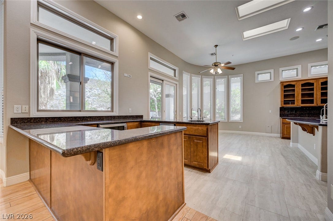 8 Starbrook Drive, Henderson, NV 89052 Gleaming stone countertops and warm wood cabinetry anchor this light-filled culinary space with built-in skylights.