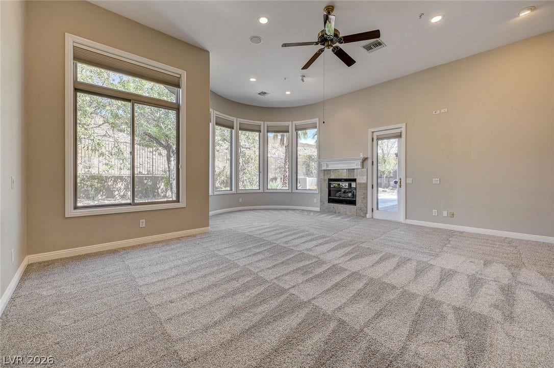 8 Starbrook Drive, Henderson, NV 89052 A fireplace anchors the expansive living area highlighted by a curved wall of windows.