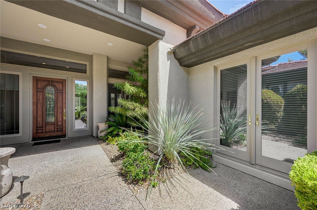 8 Starbrook Drive, Henderson, NV 89052 A welcoming stone entryway guides guests past lush plantings to an elegant wooden front door.